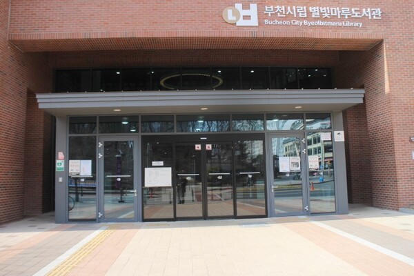 부천시립 별빛마루도서관 지상1층 주출입문은 가운데 자동문과 좌우에 여닫이문이 설치됐으며, 여닫이문 앞바닥에 점자블록이 설치돼 있다. ©박종태