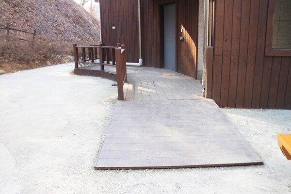 진천군 생거진천자연휴양림 산림문화휴양관 내에 마련된 장애인 객실 출입문 앞에 설치된 경사로. 턱이 있어 휠체어로 이동하는데 불편이 따른다. ©박종태