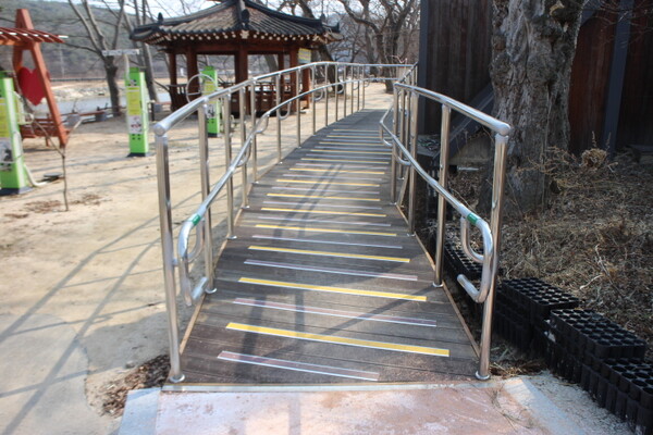 화순군 둔동마을 숲정이 공중화장실 입구에 경사로가 완만한 경사도로 설치돼 있어 휠체어를 사용하는 장애인이 이용하기 편하다. ©박종태