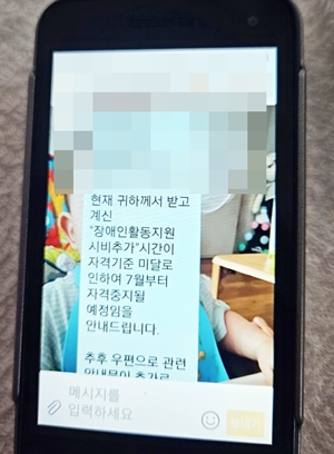 지난 23일 오후 해당 구청이 보내온 서울시 장애인활동지원 시비추가 자격 중지 문자. ©에이블뉴스