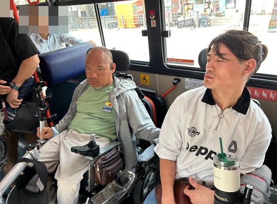 비폭력·불복종 버스행동을 진행하고 있는 서울장애인차별철폐연대 이규식 대표(왼쪽)와 유진우 활동가(오른쪽). ⓒ전국장애인차별철폐연대