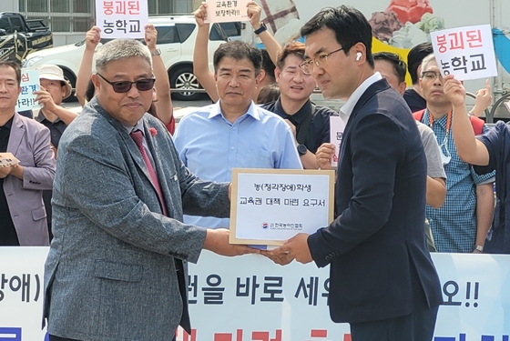 한국농아인협회 채태기 회장이 대통령실 관계자에게 ‘농인과 그 가족 3만인 서명운동’의 서명서와 정책제안서를 전달하고 있다. ⓒ에이블뉴스