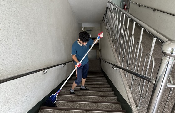 홍우진 씨가 새롬재활요양병원 계단을 청소하고 있다. ⓒ경상남도장애인부모연대