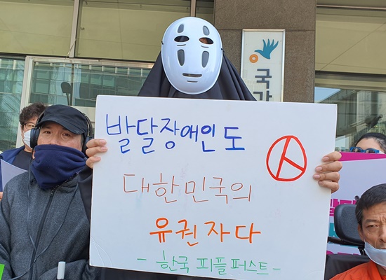 가오나시 가면을 쓴 채 ‘발달장애인도 대한민국 유권자다’ 피켓을 들고 있는 활동가.ⓒ에이블뉴스DB