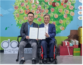 지난 12일 한국장애인재활협회 조성민 사무총장(사진 왼쪽)과 착한기술융합사회 김수한 이사장이 업무 협약서를 들고 기념촬영을 하고 있다. ©한국장애인재활협회