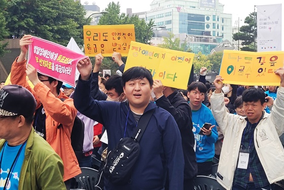 19일 오후 2시 서울 청계광장에서 열린 ‘제10회 한국피플퍼스트대회’에서 피켓을 들고있는 발달장애인 당사자와 조력자들. ©에이블뉴스