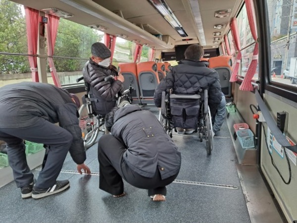 휠체어를 나래버스 바닥에 고정하고. ⓒ이복남