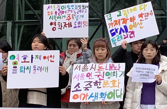 서울시의 장애인인권영화제 예산 미집행에 반발하는 피켓을 들고있는 사람들. ⓒ서울장애인인권영화제