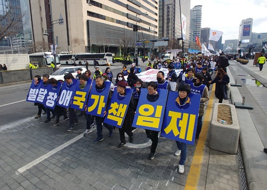 전국장애인부모연대 소속 회원들이 발달장애인 국가책임제 도입을 촉구하며 행진을 하는 모습. ⓒ에이블뉴스DB