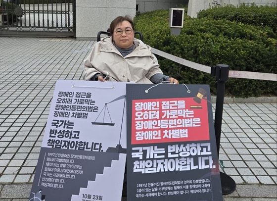 장애인차별금지추진연대 박김영희 상임대표가 7일 대법원 정문 앞에서 장애인 접근권에 대한 국가배상책임 공개변론 대법원 판결 촉구 1인 시위를 하는 모습. ⓒ장애인차별금지추진연대​​​​​​​