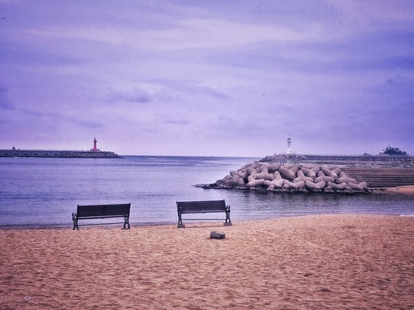 해변과 멀리 보이는 등대, 평화로운 분위기에서 한가로이 쉬고 싶은 곳