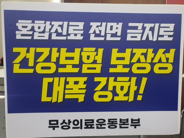 작년 3월 14일 무상의료운동본부가 참여연대 2층 아름드리홀에서 개최한 제22대 국회의원 선거 정책 요구안 발표 기자회견 당시 본부가 주장한 요구안 중의 하나인 ‘혼합진료 전면 금지로 건강보험 보장성 대폭 강화’ 문구 팻말. ⓒ이원무