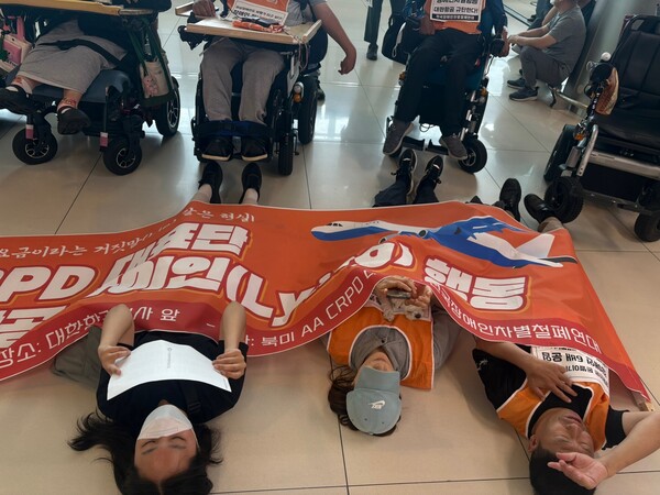 전국장애인차별철폐연대(전장연)가 28일 김포공항 국내선에서 와상장애인의 6배 항공요금에 항의하며 눕는 행위를 뜻하는 라이인(Lying) 행동을 진행했다.ⓒ전국장애인차별철폐연대