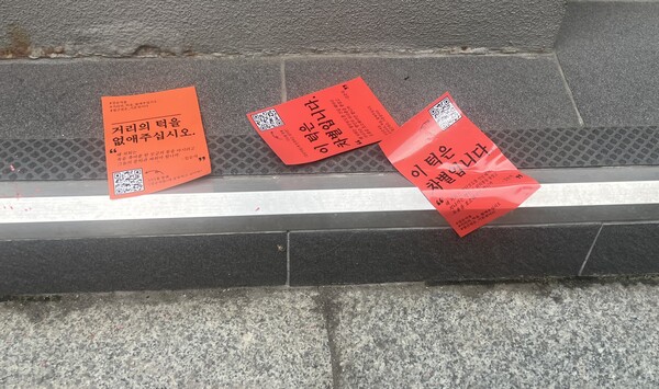 서울 광화문광장 인근 상점 입구 턱 앞에 '거리의 턱을 없애주십시오', '이 턱은 차별입니다'라는 스티커가 붙여있다.ⓒ전국장애인차별철폐연대
