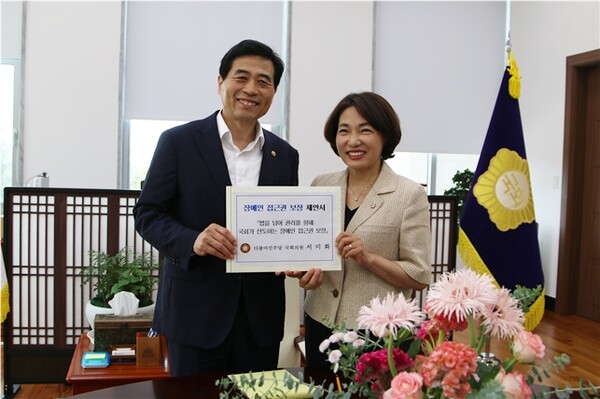 29일 더불어민주당 서미화 의원(사진 오른쪽)이 김민기 국회사무총장에게 ‘국회가 선도하는 장애인 접근권 보장’ 제안서를 전달하고 있다. ©서미화의원실