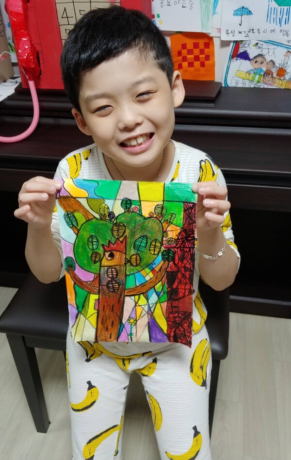 습작품이 완성되면 항상 사진찍기를 좋아했던  초등 2학년 시절 양예준 작가. ©장윤경