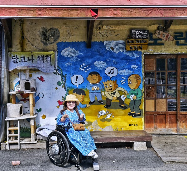 철길마을 벽화 앞의 여행자 미소. ©하석미