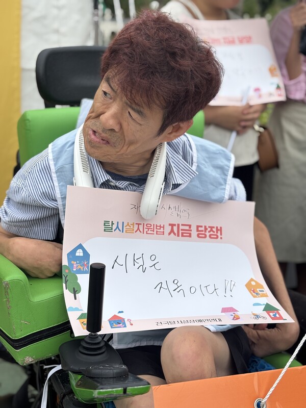 '시설은 지옥이다' 피켓을 든 중증장애인 탈시설 당사자.ⓒ전국탈시설장애인연대