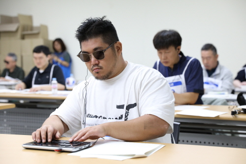 17일 강원도 강릉에서 열린 제42회 전국장애인기능경기대회에서 점역교정(시각중증) 직종 경기에 참여한 선수가 손끝으로 글씨를 읽고 있다. ⓒ한국장애인고용공단