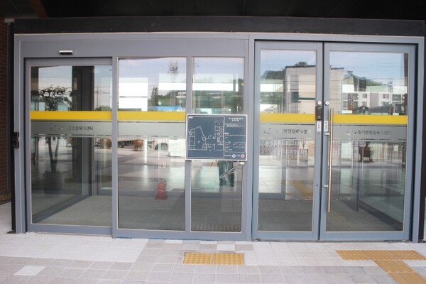옥서면행정복지센터 1층 주출입문은 자동문과 여닫이문이 설치됐으며, 여닫이문 앞바닥에 점자블록이 설치돼 있다. 주출입문 옆 시각장애인이 손끝으로 만져 건물 내부를 알 수 있는 점자안내판에는 점자를 읽지 못하는 시각장애인을 위한 음성안내기가 설치된 반면 인적서비스를 요청할 수 있는 직원호출벨이 없다. ©박종태