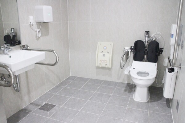 계룡국민체육센터 남녀장애인화장실 내부는 대변기에 자동 물 내림 센서와 등받이가 설치됐으며, 비상호출벨과 휴지걸이는 대변기에 앉았을 때 손이 닿는 곳에 위치에 있다. 세면대 양쪽 손잡이는 휠체어 접근을 용이하게 하는 상하가동식인 반면, 세면대 밑은 배관 구조물이 있어 휠체어 접근을 방해할 것으로 보였다. ©박종태