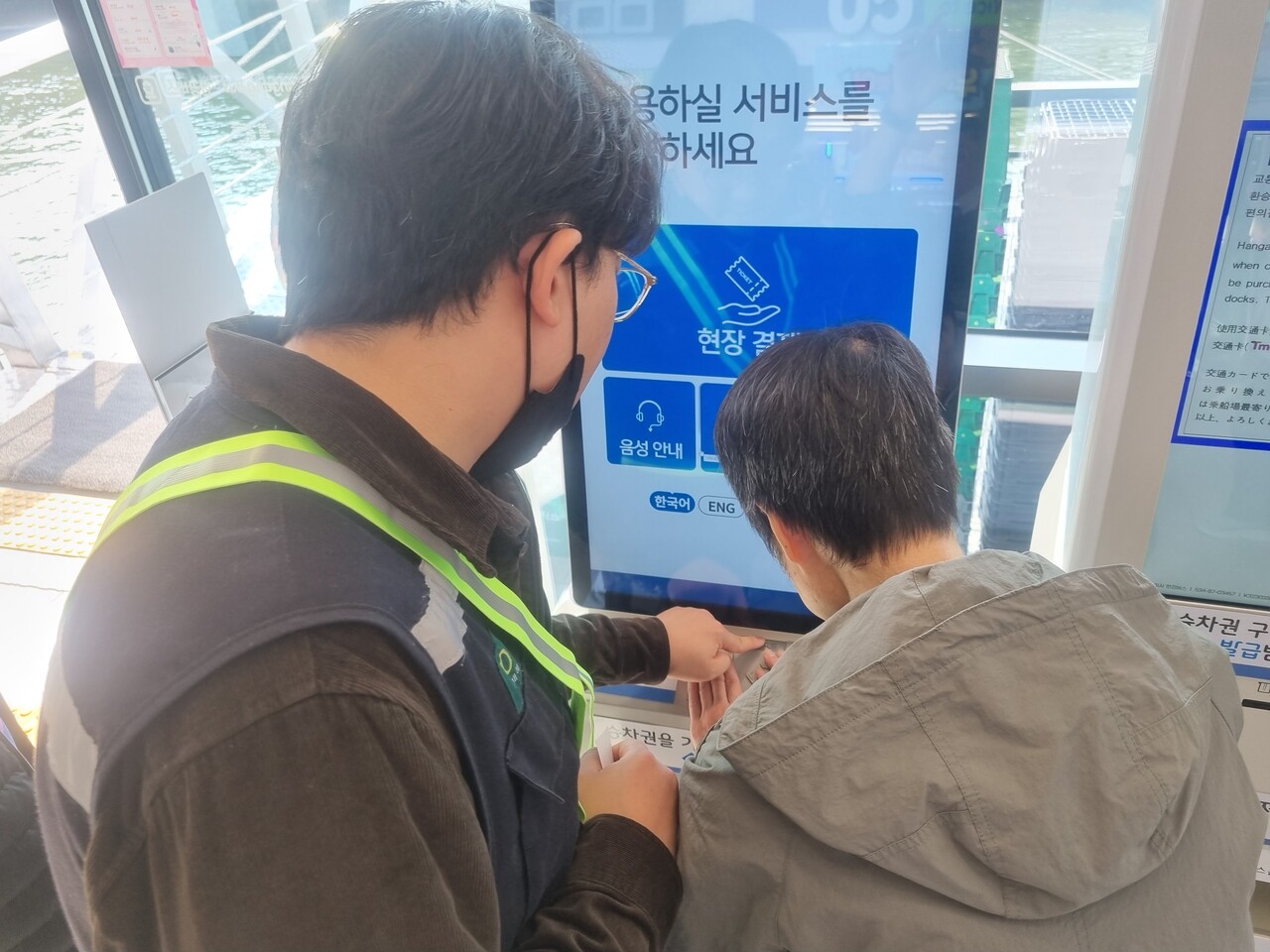 필자가 현장 직원의 안내를 받아 점자 키오스크를 살펴보고 있다.©조현대