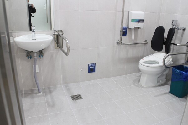익산시 금마면행정복지센터 남녀장애인화장실 내부는 대변기에 자동 물 내림 센서와 등받이가 설치됐으며, 비상호출벨과 휴지걸이는 대변기에 앉았을 때 손이 닿는 곳에 위치에 있다. 세면대 양쪽 손잡이는 휠체어 접근을 용이하게 하는 상하가동식인 반면, 세면대 밑은 배관 구조물이 있어 휠체어 접근을 방해할 것으로 보였다. ©박종태