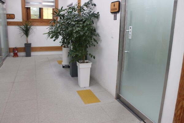익산시 금마면행정복지센터 남녀비장애인화장실 입구 벽면에는 시각장애인이 손끝으로 만져 성별을 알 수 있는 점자표지판, 앞바닥에 점자블록이 양호하게 설치됐다. ©박종태