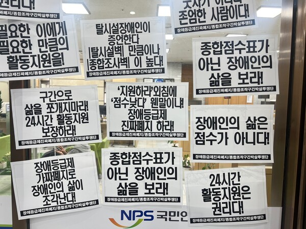 국민연금공단 서울남부지역본부 내부에 ‘24시간 활동지원 보장하라’, ‘장애인의 삶은 점수가 아니다’ 등의 종이가 붙여져 있다.ⓒ전국장애인차별철폐연대