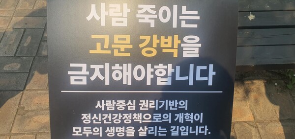 '사람 죽이는 고문 강박을 금지해야합니다.', '사람중심 권리기반의 정신건강정책으로의 개혁이 모두의 생명을 살립니다.' 현수막
