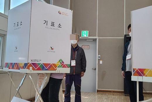 참관인이 멀찍이 지켜보고 있는 가운데, 조력인과 함께 기표소에 들어가 투표를 하는 모습.ⓒ에이블뉴스DB