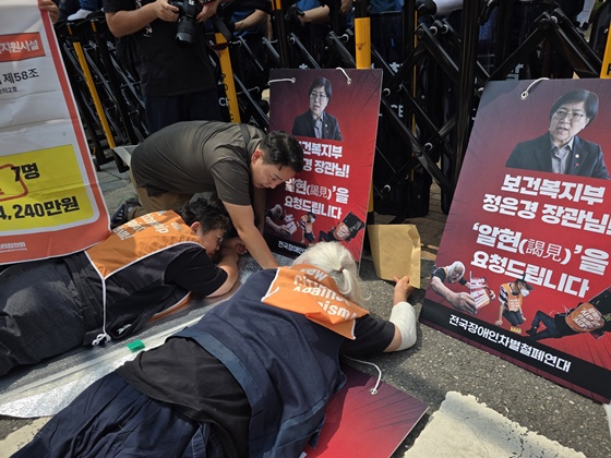 전국장애인차별철폐연대는 18일 오전 11시 한국재정정보원 앞에서 기자회견을 열고 보건복지부 정은경 장관 자택까지 행진해 포체투지를 진행하려 했으나 정은경 장관 자택 앞 경찰이 설치한 펜스에 가로막혀 있었다. 이에 장애인들과 활동가들은 경찰 펜스 앞에서 포체투지를 진행했다.©전국장애인차별철폐연대